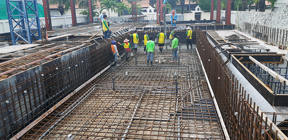 Builders Pouring Concrete for a New Swimming Pool